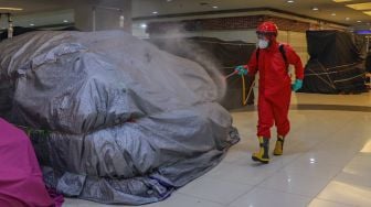 Petugas menyemprot disinfektan di Blok M Square, Jakarta Selatan, Selasa (23/6). [Suara.com/Alfian Winanto]