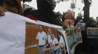 Salah satu orang tua siswa yang tergabung dalam Gerakan Emak-Bapak Peduli Keadilan dan Pendidikan (Geprak) berorasi saat melakukan aksi unjuk rasa di depan Balai Kota DKI Jakarta, Selasa (23/6). [Suara.com/Angga Budhiyanto]