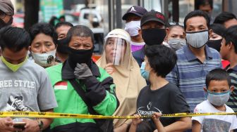 Warga saat melihat rekonstruksi kelompok John Kei di Perumahan Green Lake City, Kota Tangerang, Banten, Rabu (24/6). [Suara.com/Alfian Winanto]
