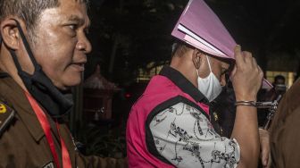 Salah satu pejabat aktif dari Direktorat Jenderal Bea dan Cukai Batam (kanan) menutupi wajahnya dengan kertas saat menuju mobil tahanan seusai menjalani pemeriksaan di Gedung Bundar, Kejaksaan Agung, Jakarta, Rabu (24/6/2020). [ANTARA FOTO/Aprillio Akbar]