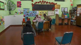 Suasana saat pembagian rapor di SDN 01 Menteng, Jakarta Pusat, Kamis (25/6). [Suara.com/Alfian Winanto]