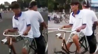 Aksi Kocak Dua Lelaki Naik Sepeda Tandem Saling Membelakangi