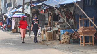 Pedagang tertidur diatas lapak dagangnya di Pasar Enjo, Jakarta Timur, Jumat (26/6). [Suara.com/Alfian Winanto]