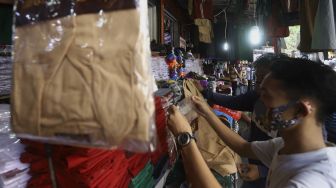 Pedagang seragam sekolah melayani pembeli di Pasar Jatinegara, Jakarta, Selasa (30/6). [Suara.com/Angga Budhiyanto]