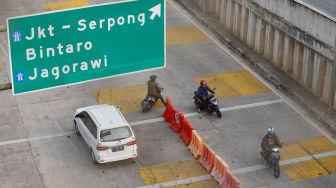 Pengendara motor berputar balik dan melawan arah di depan Gerbang Tol Ciledug, Jakarta Selatan, Rabu (1/7).  [Suara.com/Alfian Winanto]