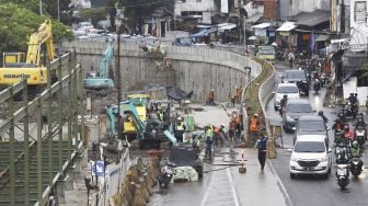 Sejumlah kendaraan melintas di samping proyek lintas bawah (Underpass) Senen, Jakarta, Kamis (2/7). [Suara.com/Angga Budhiyanto]