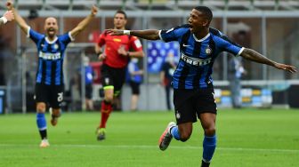 Pemain tengah Inter Milan, Ashley Young, merayakan golnya setelah membuka skor selama pertandingan sepak bola Serie A Italia, Inter Milan melawan Brescia di stadion Giuseppe-Meazza, Milan, Italia, Kamis (2/7) dini hari WIB. Miguel MEDINA / AFP