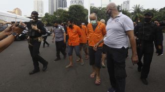 Sejumlah tersangka dihadirkan saat pemusnahan barang bukti hasil penangkapan jaringan narkoba internasional Iran –Timur Tengah di Lapangan Promoter Ditlantas Polda Metro Jaya, Jakarta, Kamis (2/7). [Suara.com/Angga Budhiyanto]