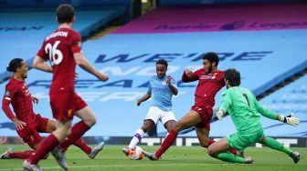 Gelandang Inggris Manchester City Raheem Sterling (C) menembak untuk mencetak gol kedua mereka selama pertandingan sepak bola Liga Inggris antara Manchester City melawan Liverpool di Stadion Etihad di Manchester, Inggris, Jumat (3/7) dini hari WIB. [Dave Thompson / POOL / AFP]
