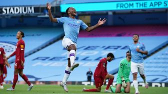 Gelandang Inggris Manchester City Raheem Sterling (C) melompat untuk merayakan usai mencetak gol kedua timnya selama pertandingan sepak bola Liga Inggris antara Manchester City melawan Liverpool di Stadion Etihad di Manchester, Inggris, Jumat (3/7) dini hari WIB.
[Dave Thompson / POOL / AFP]
