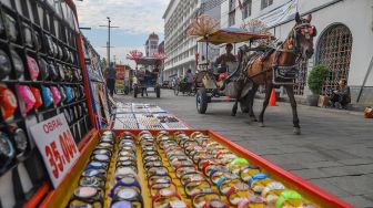 Delman melintas di kawasan Kota Tua, Jakarta Barat, Sabtu (4/7). [Suara.com/Alfian Winanto]
