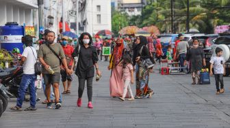 Wisatawan berkunjung ke kawasan Kota Tua, Jakarta Barat, Sabtu (4/7). [Suara.com/Alfian Winanto]
