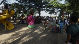 Sejumlah warga beraktivitas saat Hari Bebas Kendaraan Bermotor (HBKB) atau Car Free Day (CFD) di kawasan Banjir Kanal Timur (BKT), Duren Sawit, Jakarta, Minggu (5/7). [Suara.com/Angga Budhiyanto]