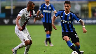 Pemain depan Inter Milan Lautaro Martinez (kanan) bersaing dengan bek Bologna Brasil Danilo selama pertandingan sepak bola Serie A Italia antara Inter Milan melawan Bologna di stadion Giuseppe-Meazza, Milan, Italia, Minggu (5/7). [MIGUEL MEDINA / AFP]