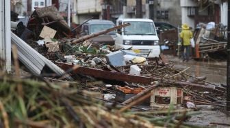 Sebuah jalan tertutup oleh Puing-puing di daerah yang terkena banjir setelah hujan lebat di Hitoyoshi, Prefektur Kumamoto, Jepang, pada 5 Juli 2020. [STR / JIJI PRESS / AFP]
