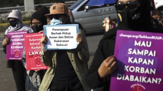 Massa yang tergabung dalam Gerak Perempuan membawa poster penolakan saat melakukan aksi unjuk rasa di depan gedung Dewan Perwakilan Rakyat Republik Indonesia (DPR RI), Jakarta, Selasa (7/7). [Suara.com/Angga Budhiyanto]