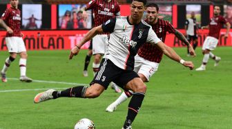 Penyerang Juventus Cristiano Ronaldo menendang bola selama pertandingan sepak bola Serie A Italia AC Milan melawan Juventus di Stadion San Siro, Milan, Rabu (8/9) dini hari WIB. [Miguel MEDINA / AFP]
