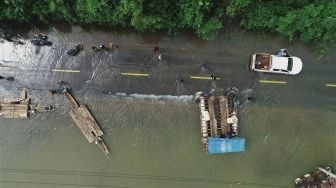 Sejumlah kendaraan terjebak banjir dan terpaksa diievakuasi dengan menggunakan rakit di jalan trans sulawesi di Desa Sambandete, Kabupaten Konawe Utara, Sulawesi Tenggara, Rabu (8/7/2020).  [ANTARA FOTO/Asrun]