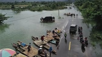 Suasana kendaraan terjebak banjir dan terpaksa diievakuasi dengan menggunakan rakit di jalan trans sulawesi di Desa Sambandete, Kabupaten Konawe Utara, Sulawesi Tenggara, Rabu (8/7/2020).  [ANTARA FOTO/Asrun]