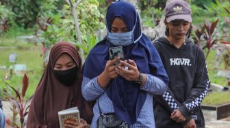 Keluarga berdoa di pemakaman Papa T Bob di TPBU Jurang Mangu, Pondok Ranji, Tangerang Selatan, Jumat (10/7). [Suara.com/Alfian Winanto]
