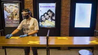 Pekerja memasang tanda jaga jarak saat simulasi pembukaan dan peninjauan tempat hiburan bioskop CGV Cinemas di Bandung Electronic Center (BEC), Bandung, Jawa Barat, Kamis (9/7). [ANTARA FOTO/M Agung Rajasa]