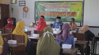 Orang tua siswa baru mengikuti pengarahan saat Masa Pengenalan Lingkungan Sekolah (MPLS) di SDN Lawangan Daya 2, Pamekasan, Jawa Timur, Sabtu (11/7). [ANTARA FOTO/Saiful Bahri]