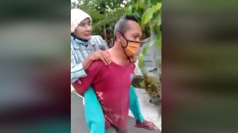 Salut! Ketua RT Jalan Kaki Gendong Lansia Antar ke Posko Bantuan Covid-19