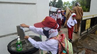 Sejumlah murid mencuci tangan sebelum masuk hari pertama sekolah di SDN 11 Marunggi Pariaman, Sumatera Barat, Senin (13/7/2020). [Foto/Antara]
