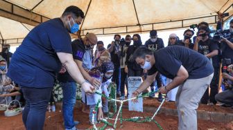 Ivan Gunawan menaruh bunga diatas pusara ayahnya, Bambang Cahyo Gunawan di TPU Kampung Kandang, Jagakarsa, Jakarta Selatan, Senin (13/7). [Suara.com/Alfian Winanto]