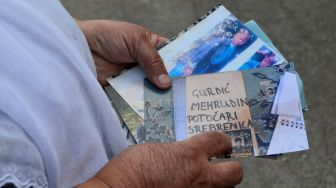 Kerabat korban Genosida Srebrenica menunjukan foto korban selama upacara peringatan di Srebrenica, Bosnia dan Herzegovina pada 13 Juli 2020. [Foto/Anadolu Agency]