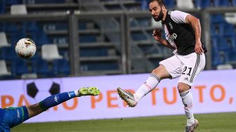 Pemain depan Juventus Gonzalo Higuain melakukan tendangan dan mencetak gol selama pertandingan sepak bola Serie A Italia, Sassuolo melawan Juventus di Stadion Mapei, Reggio, Italia, Kamis (16/7) dini hari WIB. [MARCO BERTORELLO / AFP]
