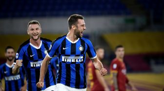 Bek Inter Milan Stefan de Vrij (C) merayakan golnya dengan rekan satu tim setelah mencetak gol selama pertandingan sepak bola Serie A Italia antara AS Roma melawan Inter Milan di Stadion Olimpico, Roma, Italia, Senin (20/7) dini hari WIB. [Filippo MONTEFORTE / AFP]