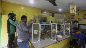 Suasana di warteg yang menerapkan protokol kesehatan di kawasan Cilandak Timur, Jakarta Selatan, Senin (20/7/2020). [Suara.com/Angga Budhiyanto]