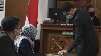 Kuasa hukum Djoko Tjandra, Andri Putra Kusuma (kanan) mempersiapkan surat permohonan saat sidang Peninjauan Kembali (PK) yang diajukan oleh buronan kasus korupsi Cassie Bank Bali, Djoko Tjandra di Pengadilan Negeri Jakarta Selatan, Senin (20/7/2020). [Suara.com/Angga Budhiyanto]