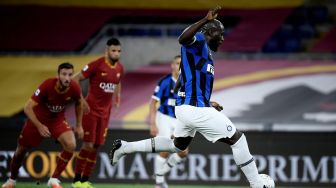 Pemain depan Inter Milan Romelu Lukaku (kanan) menembak dan mencetak gol dari tendangan penalti selama pertandingan sepak bola Serie A Italia antara AS Roma melawan Inter Milan di Stadion Olimpico, Roma, Italia, Senin (20/7) dini hari WIB. [Filippo MONTEFORTE / AFP]