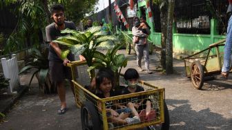 Pedagang mengangkut tanaman hias yang telah dibeli pengunjung di sentra penjualan tanaman di kawasan Ragunan, Jakarta, Minggu (19/7/2020). [ANTARA FOTO/Indrianto Eko Suwarso]