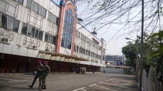 Prajurit Marinir berjalan di depan toko yang tutup di Pasar Asem Reges, Jakarta Barat, Selasa (21/7/2020). [ANTARA FOTO/Nova Wahyudi]