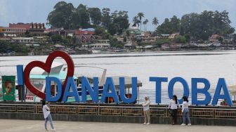 Pengunjung berfoto berlatar Danau Toba di Parapat, Sumatera Utara, Indonesia pada 21 Juli 2020. [Foto/Anadolu Agency