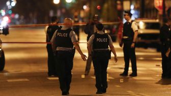 Petugas kepolisian Chicago menyelidiki lokasi penembakan di Chicago, Illinois, Amerika Serikat,  Selasa (21/7). [KAMIL KRZACZYNSKI / AFP]