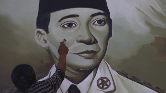 Pekerja menyelesaikan mural bertemakan Proklamasi di Sekolah Dasar Negeri (SDN) Pondok Aren 02, Tangerang Selatan, Banten, Rabu (22/7/2020). [Suara.com/Angga Budhiyanto]