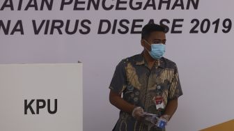 Seorang pemilih keluar dari bilik suara usai melakukan pencoblosan surat suara saat simulasi pemungutan suara Pilkada Serentak 2020 di Kantor Komisi Pemilihan Umum (KPU) Republik Indonesia, Jakarta, Rabu (22/72020). [Suara.com/Angga Budhiyanto]