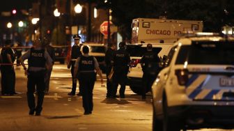 Polisi Chicago menyelidiki lokasi penembakan di Chicago, Illinois, Amerika Serikat,  Selasa (21/7). [KAMIL KRZACZYNSKI / AFP]