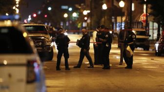 Petugas menyelidiki lokasi penembakan di Chicago, Illinois, Amerika Serikat,  Selasa (21/7). [KAMIL KRZACZYNSKI / AFP]