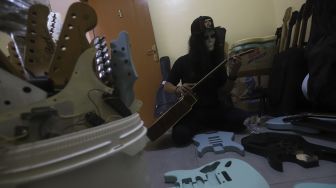 Pemilik toko dan bengkel kerja 'Music666' melakukan perawatan dan servis gitar di Ciledug, Tangerang, Banten, Rabu (22/7/2020). [Suara.com/Angga Budhiyanto]