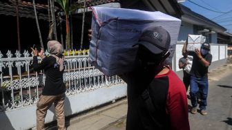 Petugas mengamankan barang bukti berupa bahan baku dari dalam pabrik pembuatan obat keras ilegal di Cibaduyut, Kabupaten Bandung, Jawa Barat, Jumat (24/7/2020). [ANTARA FOTO/Raisan Al Farisi]