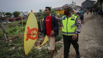 Polisi membawa warga yang menerbangkan layangan di kawasan keselamatan operasi penerbangan Bandara Soekarno Hatta, Neglasari, Kota Tangerang, Banten, Sabtu (25/7/2020). [ANTARA FOTO/Fauzan]