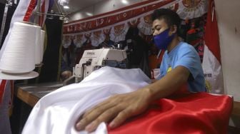 Pekerja menyelesaikan pembuatan pernak-pernik Bendera Republik Indonesia di Pasar Senen, Jakarta, Minggu (26/7/2020). [Suara.com/Angga Budhiyanto]