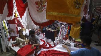 Pekerja menyelesaikan pembuatan pernak-pernik Bendera Republik Indonesia di Pasar Senen, Jakarta, Minggu (26/7/2020). [Suara.com/Angga Budhiyanto]