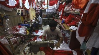 Pekerja menyelesaikan pembuatan pernak-pernik Bendera Republik Indonesia di Pasar Senen, Jakarta, Minggu (26/7/2020). [Suara.com/Angga Budhiyanto]