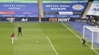 Gelandang Portugal Manchester United, Bruno Fernandes (kiri) mencetak gol pembuka dari titik penalti selama pertandingan sepak bola Liga Premier Inggris antara Leicester City melawan Manchester United di King Power Stadium di Leicester, Inggris, Minggu (26/7/2020). [Oli SCARFF / POOL / AFP]